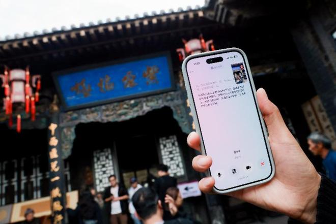 游客在山西古建前用手机体验豆包 AI 讲解。图源:南方都市报